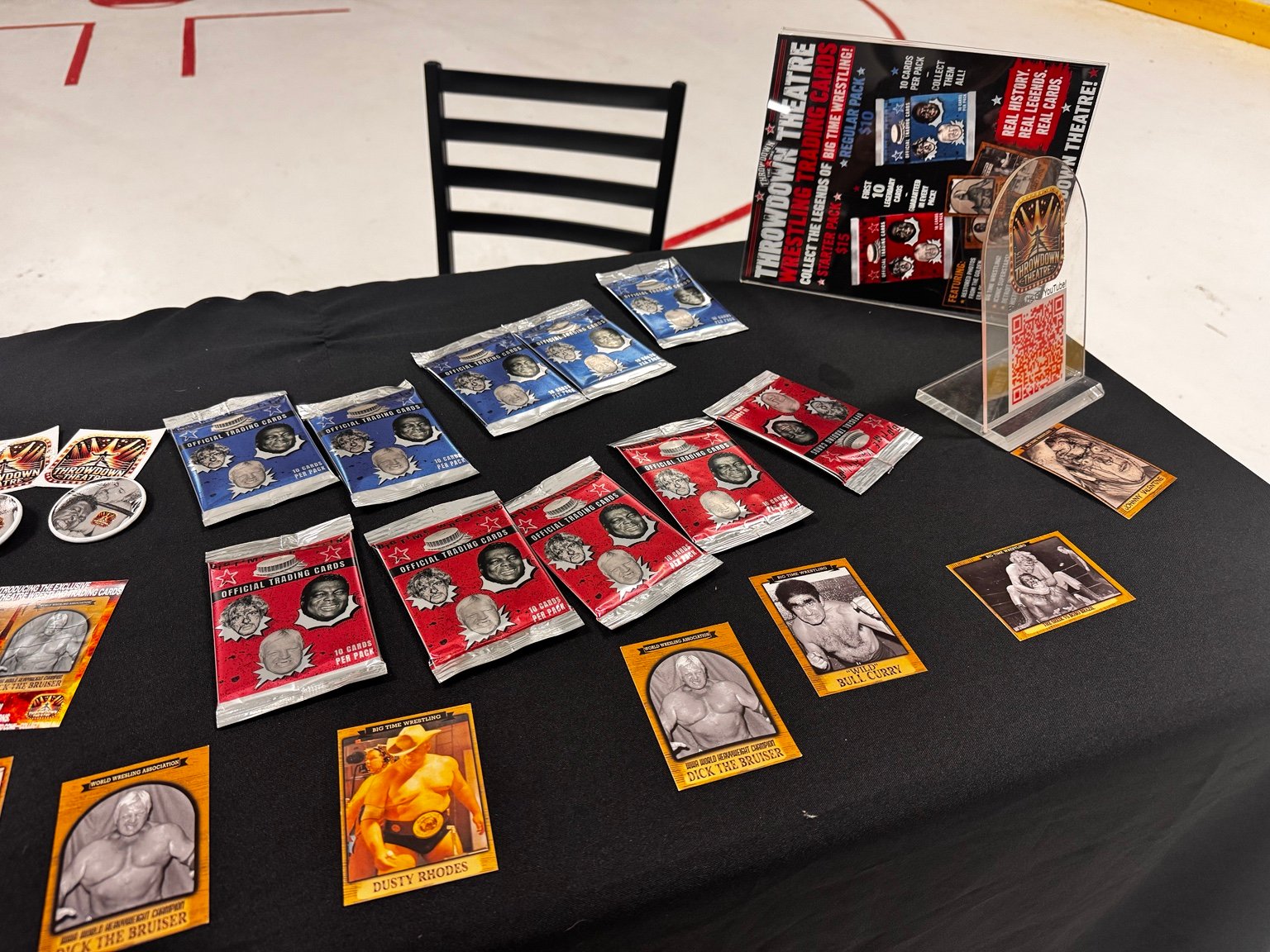 Actual Throwdown Theatre sealed trading card packs and individual cards displayed at an event
